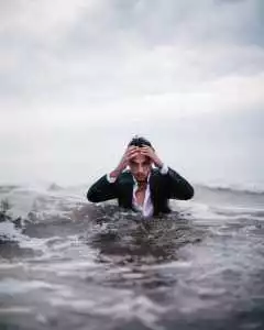 Man in suit in surf.